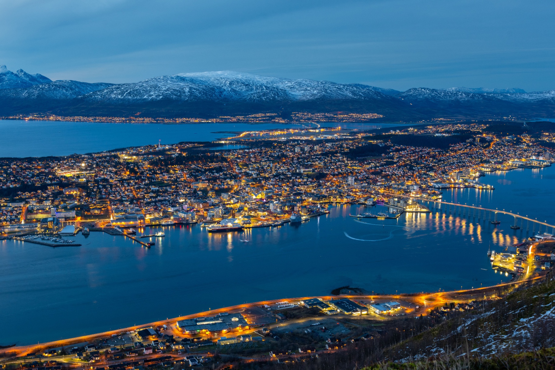 Tromsø sett ovenfra i blå time, snødekte fjell og fjord